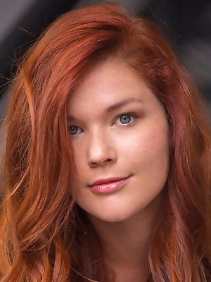 Redhead Mia Sollis, strips her see-through top baring her sexy, curvy body and   delectable pussy on the couch.